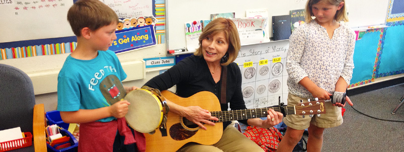 Teacher Sings With a Young Student who Plays a Tamborine