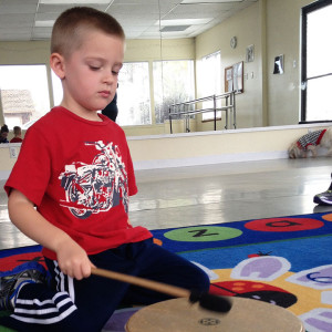 Young Student Learning How to Play a Drum